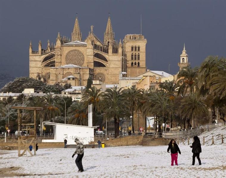 Varias personas juegan en la playa de Palma tras la fuerte nevada que ha caído en Mallorca. foto: Montserrat T.Diez
