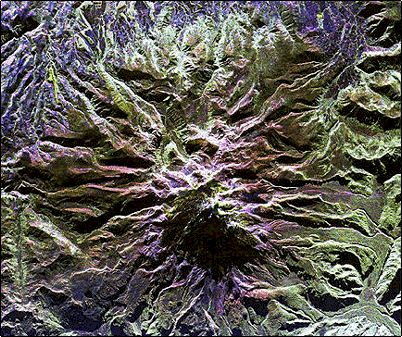 Esta fotograf�a pertenece al sistema SIRC/X-SAR de la NASA, muestra el �rea del volc�n Cayambe. En esta extraordinaria toma se puede apreciar el volc�n, sus flancos, las planicies formadas por lahares prehist�ricos y la estructura doble del cono. Los colores han sido alterados para mostrar los distintos usos del suelo, entre ellos las extensas granjas flor�colas y pastizales en la parte superior de esta foto en azul.

