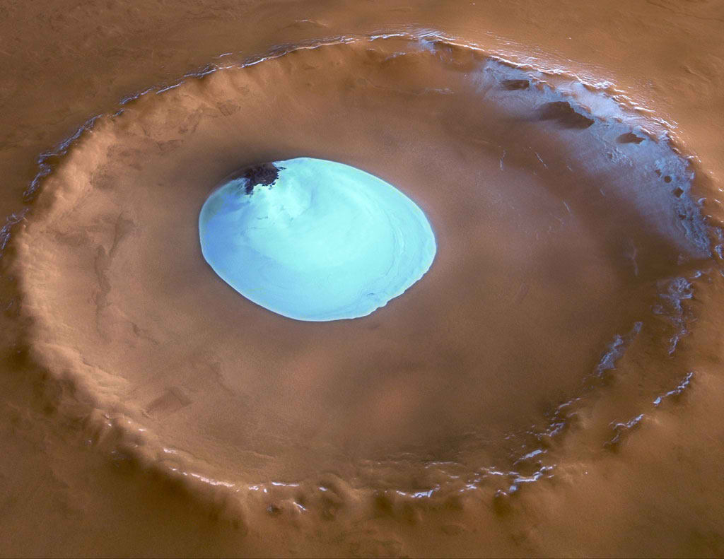 Cráter marciano mostrando un lago de agua congelada en el fondo.