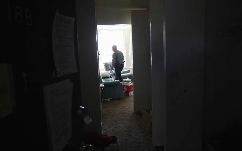 Un oficial de policía vigila un departamento antes de que sea desalojado por un equipo, los inquilinos se habían marchado antes. Foto: John Moore/Getty Images