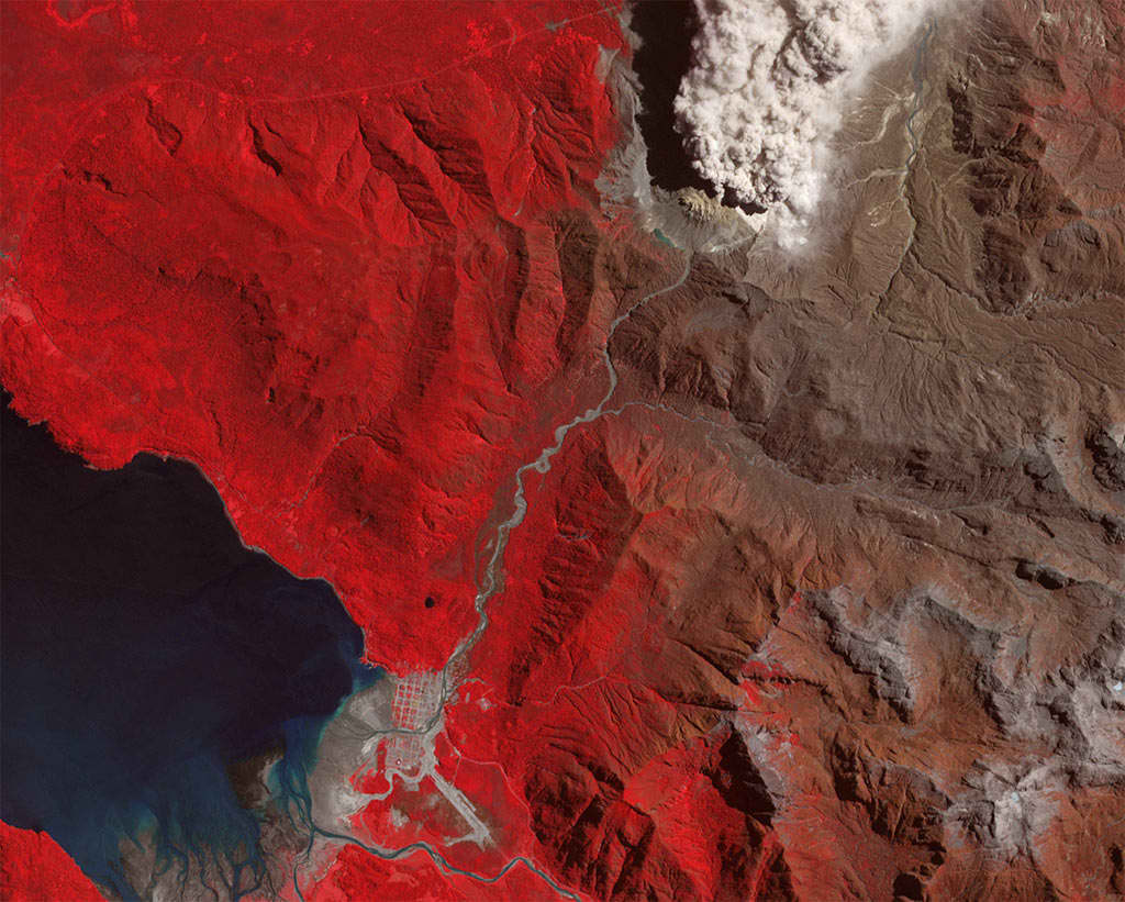 Volcán Chaitén en erupción y localidad de Chaitén en la esquina inferior izquierda de la imagen, la comuna aún es visible pese a los flujos de lahares que la han enterrado parcialmente